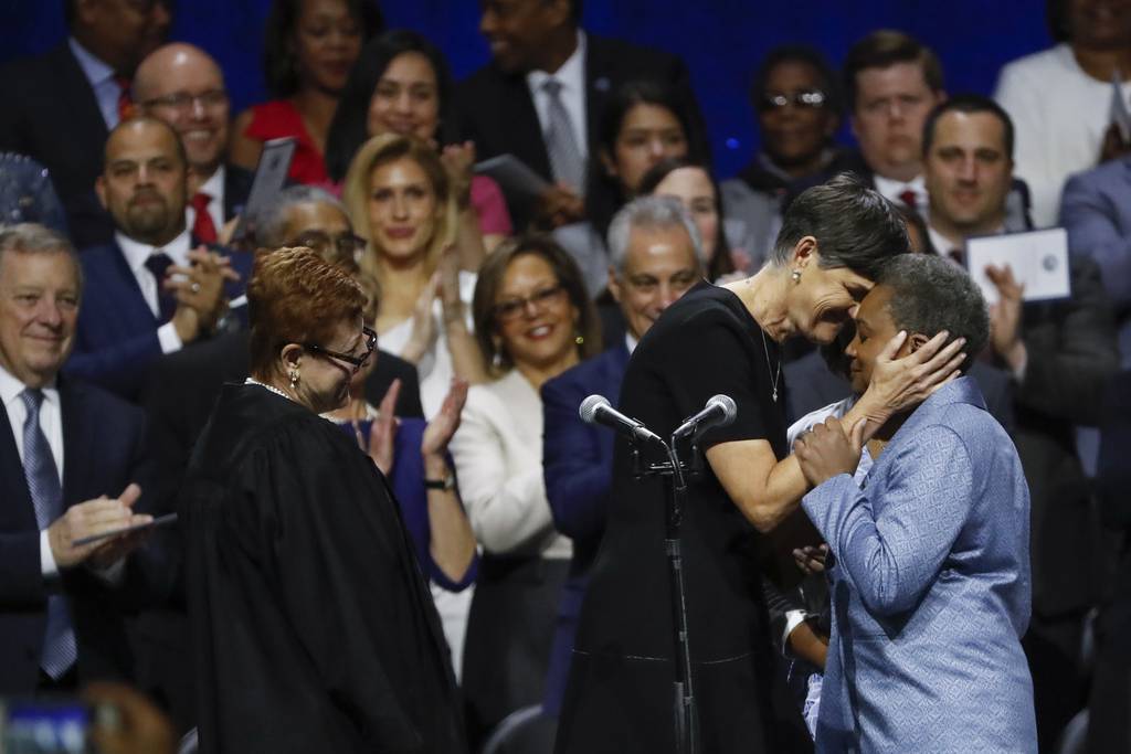 U.S. Magistrate Judge Susan Cox, left, looks on as Amy Eshleman embraces wife Lori Lightfoot after she was sworn in as mayor of Chicago at Wintrust Arena on May 20, 2019.