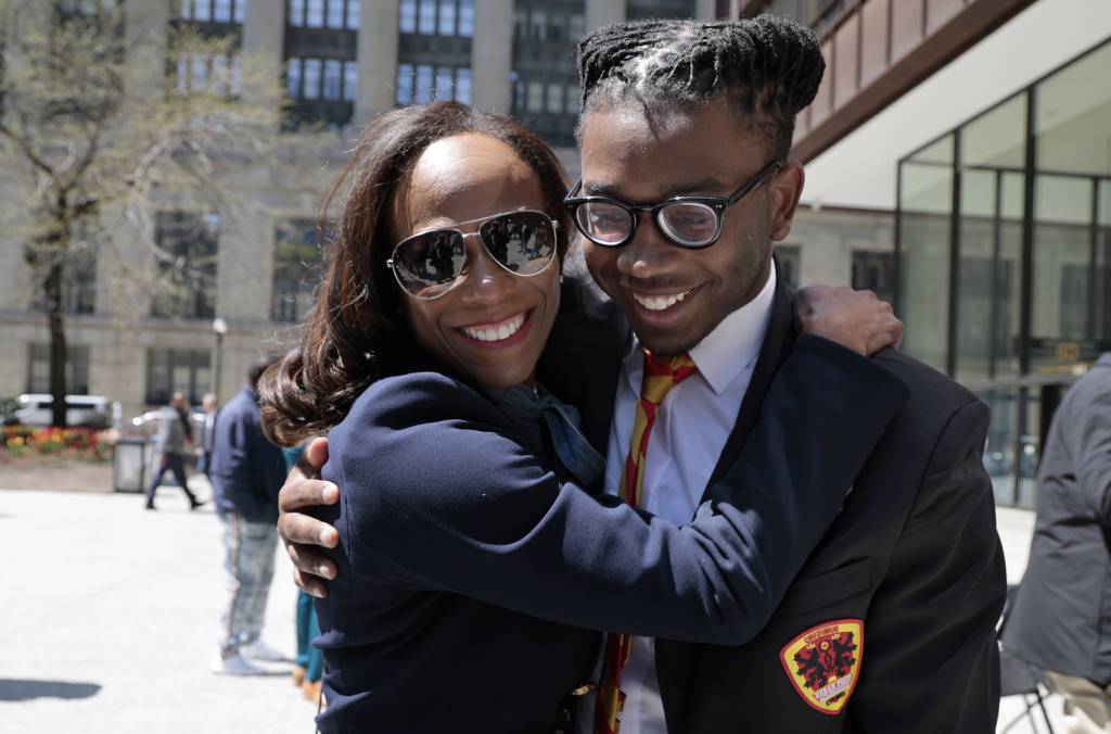 Urban Prep senior Miles Johnson receives a hug and kiss from his mother, Pamala Johnson, while attending the college signing day rally at Daley Plaza on April 27, 2023. 