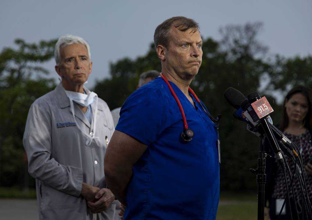 Dr. Brigham Temple speaks in front of other medical workers as they step outside NorthShore Highland Park Hospital to discuss their treatment of mass shooting victims, July 4, 2022.