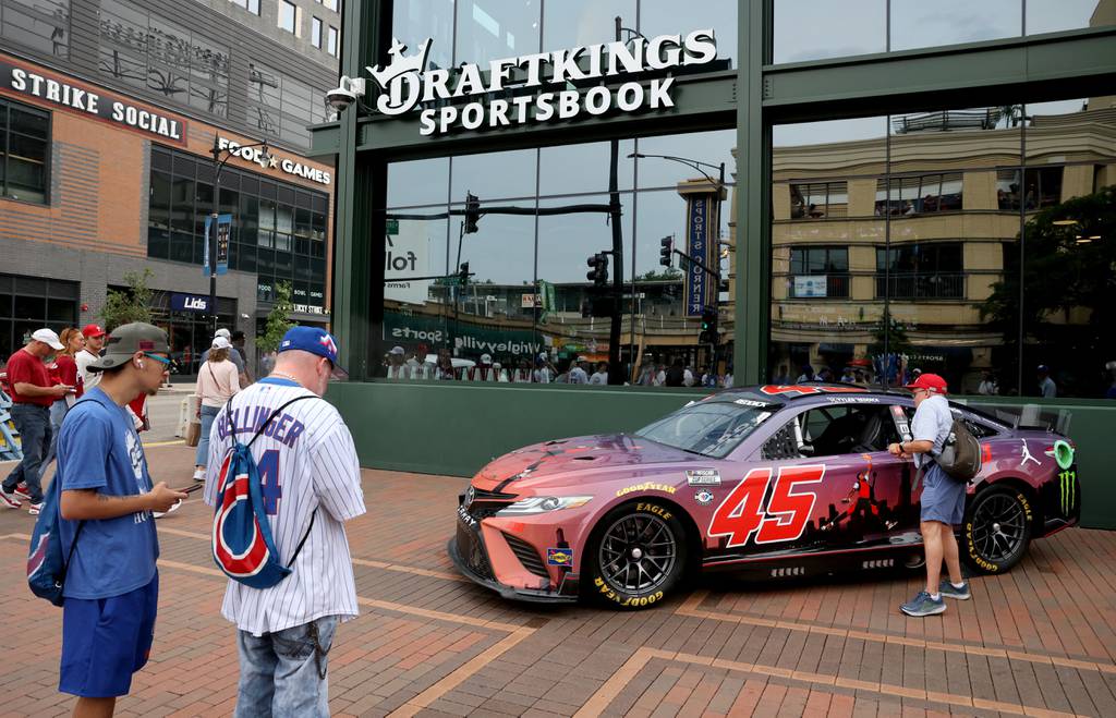 People check out a Michael Jordan-themed Bubba Wallace race car parked outside DraftKings Sportsbook and Wrigley Field on June 29, 2023.
