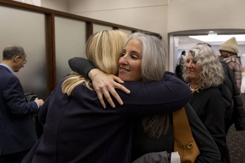 Lauren Bennett, right, who was shot multiple times at the Highland Park July Fourth parade, hugs Mayor Nancy Rotering after testifying in favor of a proposed assault weapons ban bill at an Illinois House committee hearing on Dec. 12, 2022.