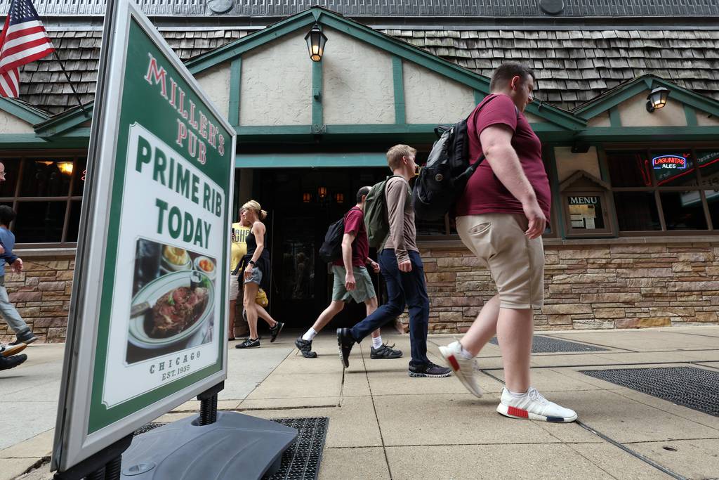 People walk past Miller’s Pub on South Wabash Avenue in Chicago's Loop on June 29, 2023.