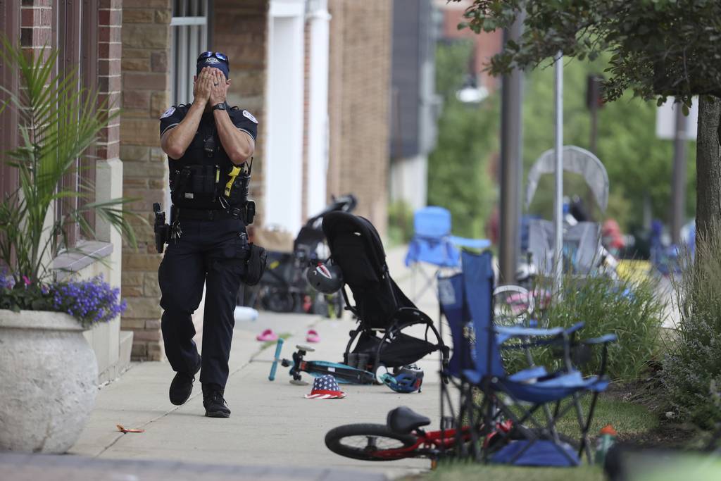 A Lake Forest police officer walks down Central Ave on July 4, 2022, after a shooter fired on the northern suburb’s Fourth of July parade. 