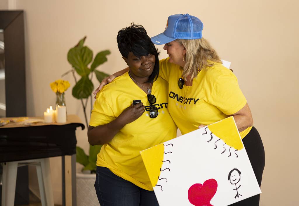 Cecilia Rodhe, right, a sculptor and certified expressive art therapist, hugs Dorothy Riles as she shares her painting on July 16, 2023.