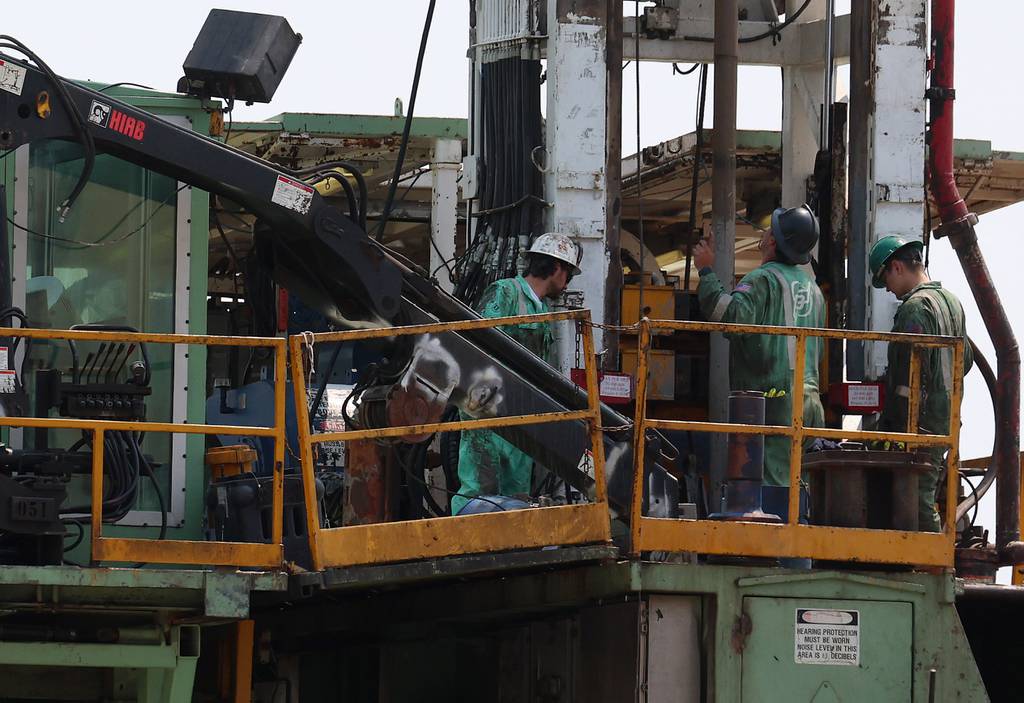 Workers stand on a platform at a Navigator CO2 drilling site in rural Nokomis.