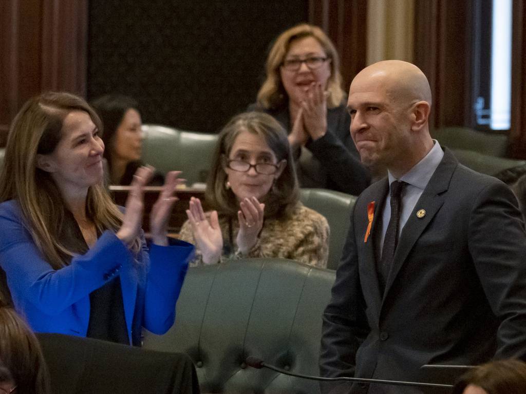 Colleagues applaud state Rep. Bob Morgan after the passage of a gun bill banning assault weapons and high capacity magazines Jan. 10, 2023, at the State Capitol in Springfield. 