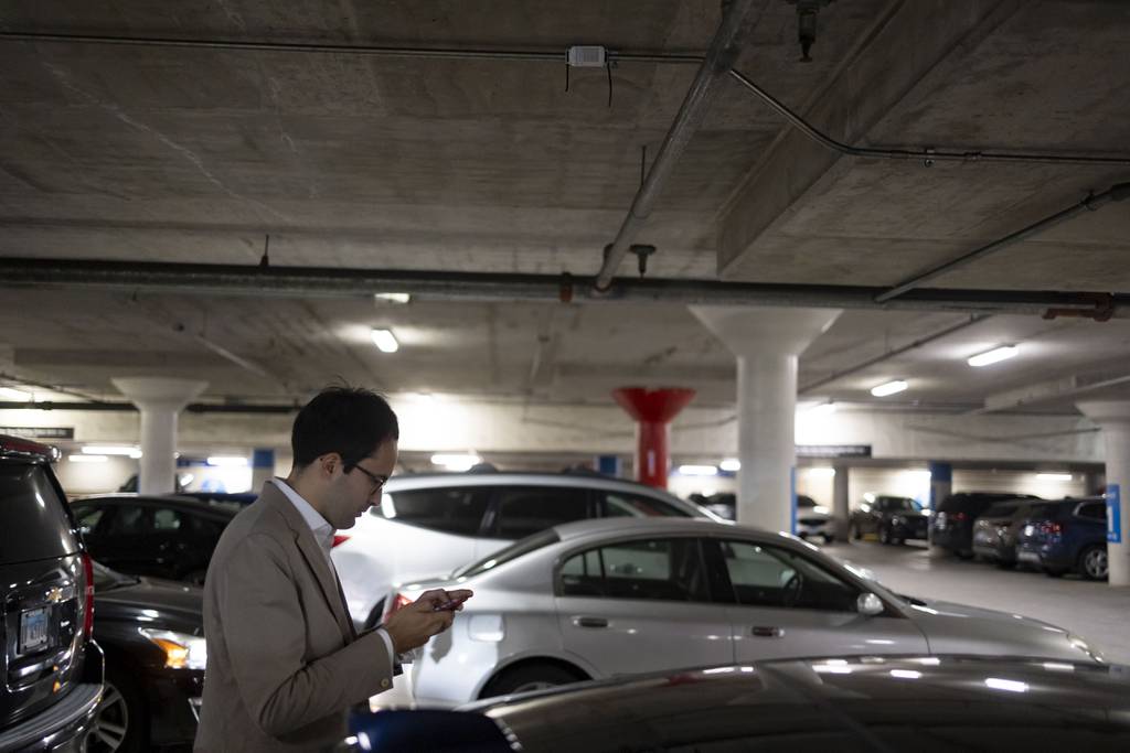 Northwestern researcher Alessandro Rotta Loria locates a temperature sensor overhead that monitors heat inside the Grant Park North parking garage on July 20, 2023. 