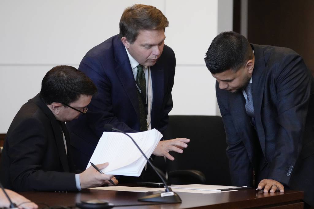Lake County State's Attorney Eric F. Rinehart, center, talks with Assistant State's Attorney Jeffrey Facklam, left, and Robert E. Crimo Jr.'s attorney George Gomez, before Judge George D. Strickland at the Lake County Courthouse, Friday, July 14, 2023, in Waukegan, Ill. Judge George Strickland on Friday set a Nov. 6 trial date for Crimo Jr. who is charged with helping his son obtain a gun license three years before the son allegedly shot dead seven people at a Fourth of July parade in suburban Chicago last year. (AP Photo/Nam Y. Huh, Pool)