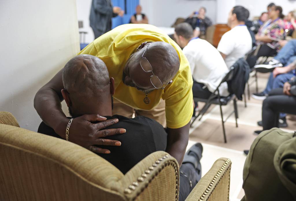 Two residents hug after a resident's testimonial during a recovery education meeting at Phoenix Recovery Support Services.