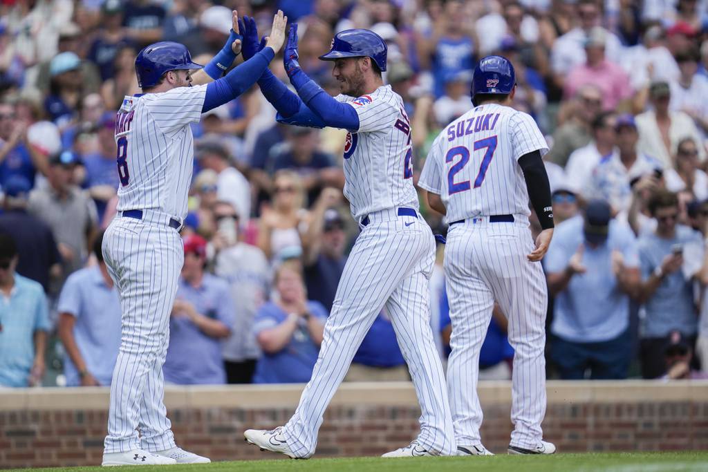 Cubs center fielder Cody Bellinger high-fives Ian Happ after hitting a grand slam during the third inning against the Red Sox on Saturday at Wrigley Field.