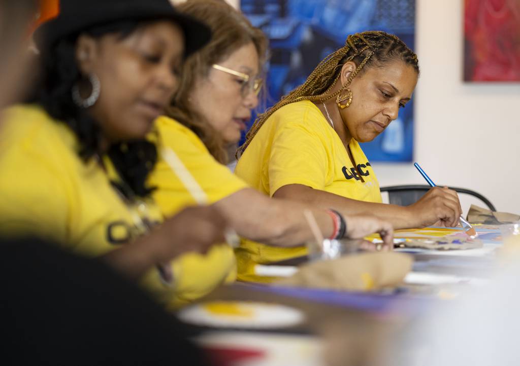 Chrissy Morgan, from left, Maria Pike and Lori Tucker work on their paintings on July 16, 2023, at Vault Gallerie in Pilsen during a Ladies of the Arc event for mothers who have lost children to gun violence. 