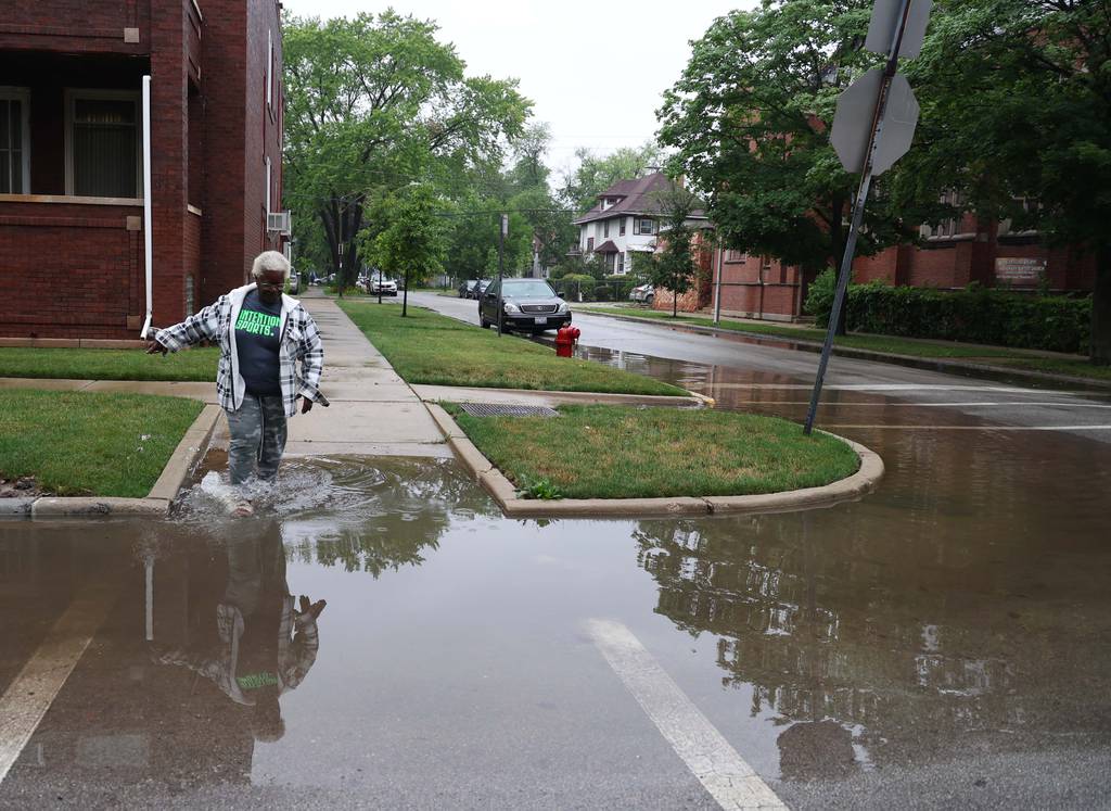 Shirley Howard makes her way across flooded streets along the 800 block of North Lockwood Avenue on July 2, 2023, in Chicago.
