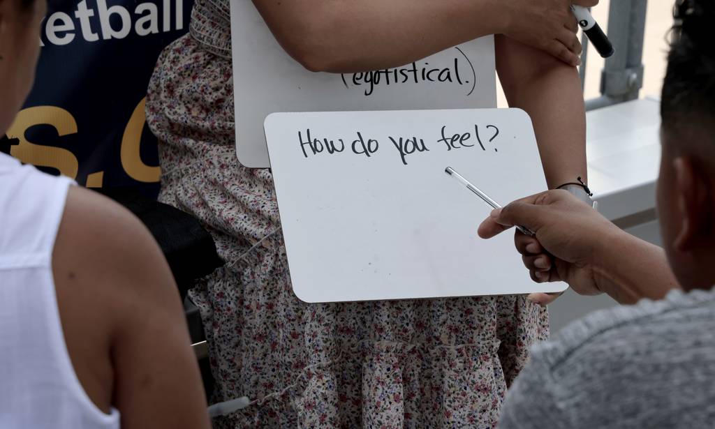 Samantha Oulavong teaches basic English to Karla Urbino at Margaret Hie Ding Lin Park under the CTA elevated tracks at 18th Street and State Street on June 29, 2023, in Chicago.