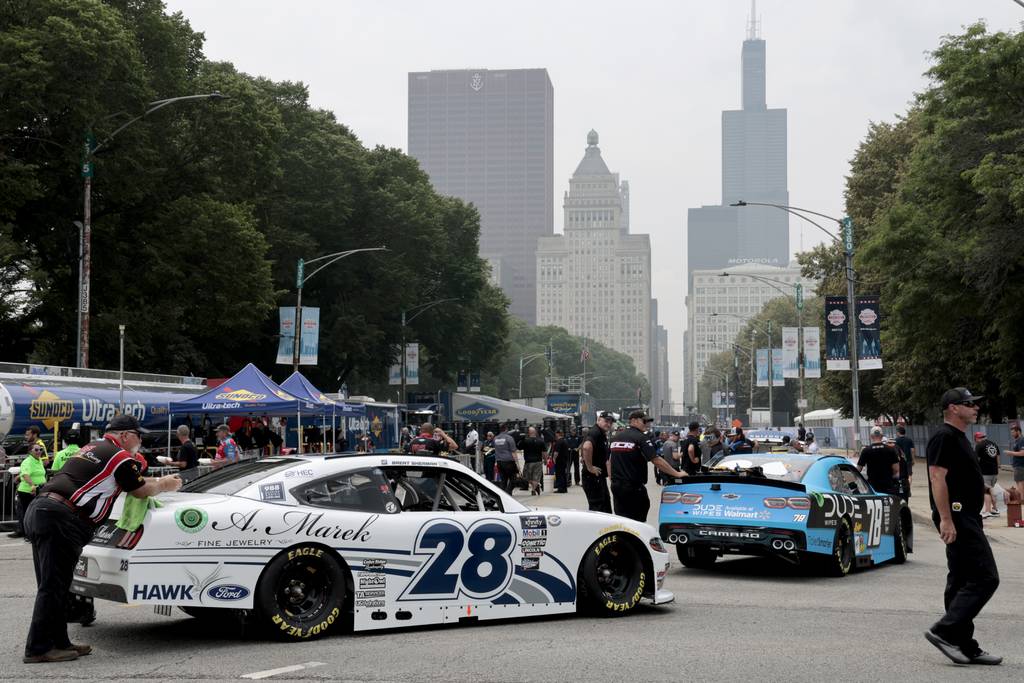 Race cars are pushed forward for inspection along Jackson Drive as preparations continue for the Inaugural NASCAR Chicago on June 30, 2023.