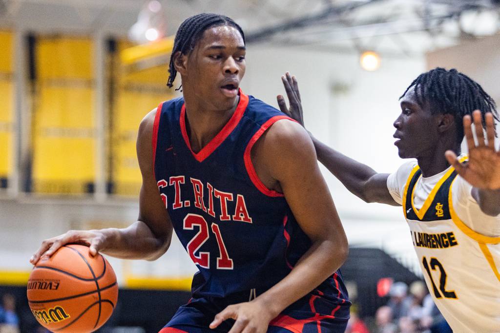 St. Rita’s Morez Johnson (21) looks to get past St. Laurence’s Caleb Davis (12) during a Catholic League crossover game in Burbank on Tuesday, Dec. 13, 2022.