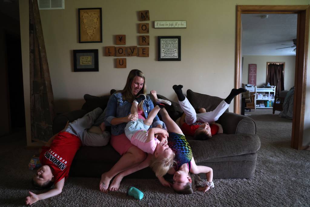 Sabrina Jones laughs as her children play on the family’s sofa in rural Nokomis.