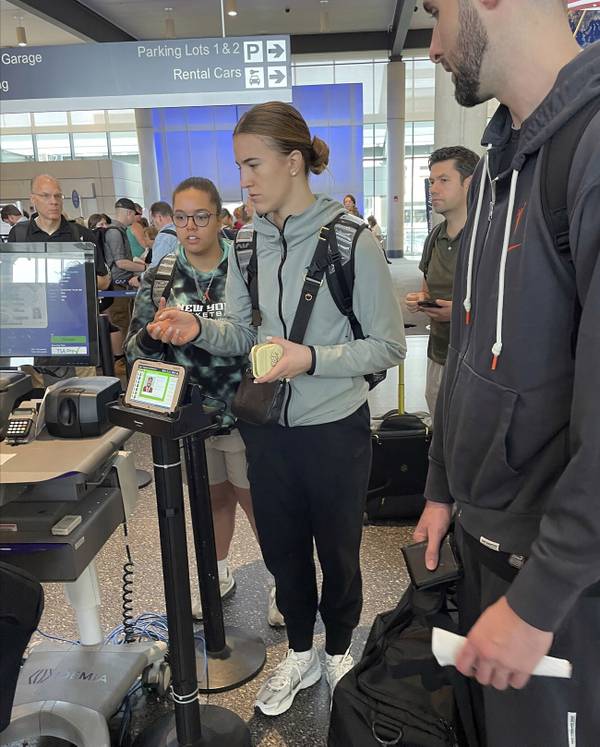 New York Liberty's Sabrina Ionescu, center, waits to go through the security line with the team's manager of basketball operations Micaela Reese behind her at Bradley Airport in Hartford, Conn., on June 25, 2023.