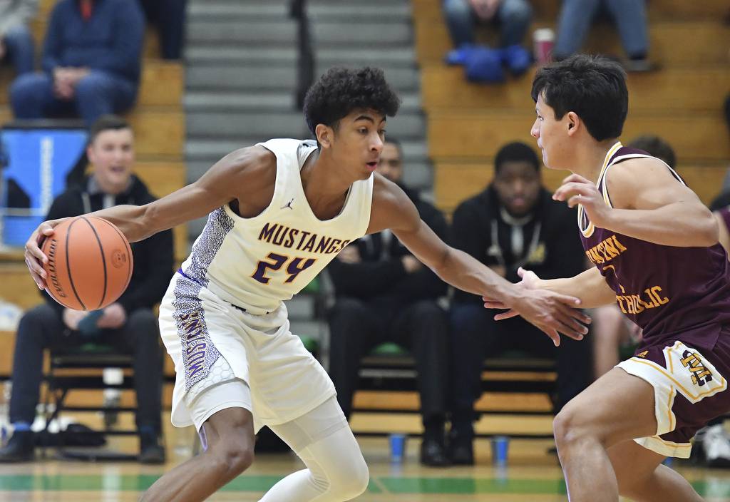 Rolling Meadows’ Cameron Christie (24) looks for a path around Montini’s Maddox Shepherd during a game in the Jack Tosh Holiday Classic at York in Elmhurst on Monday, Dec. 26, 2022.