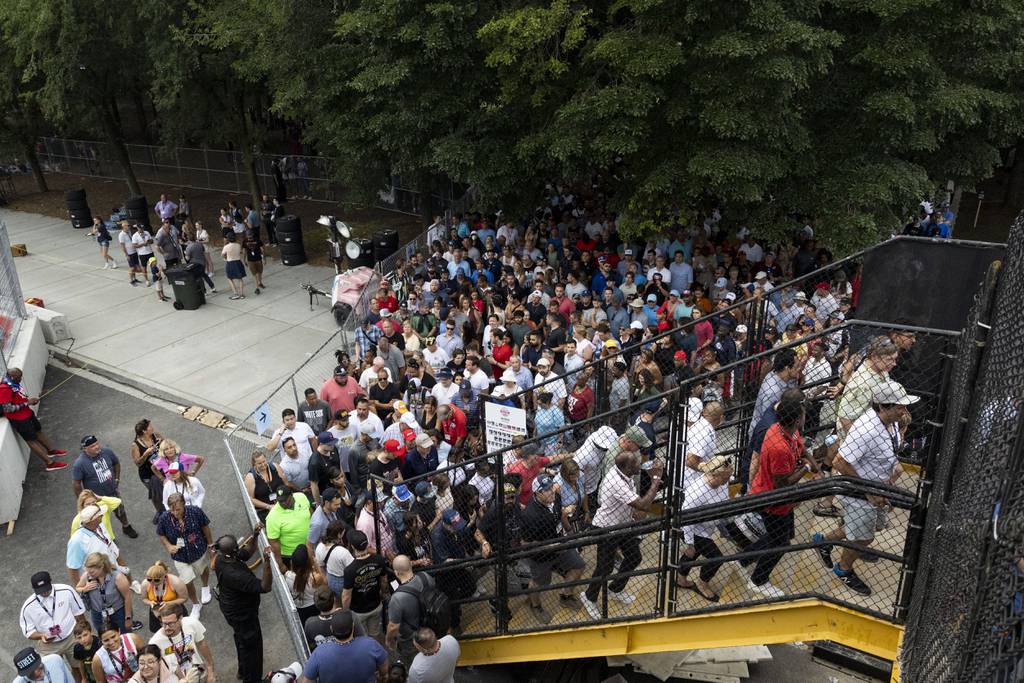 People wait to cross a pedestrian bridge over Columbus Drive because of a lightning delay during the NASCAR Xfinity Series in Grant Park in Chicago on Saturday, July 1, 2023. (Eileen T. Meslar/Chicago Tribune)