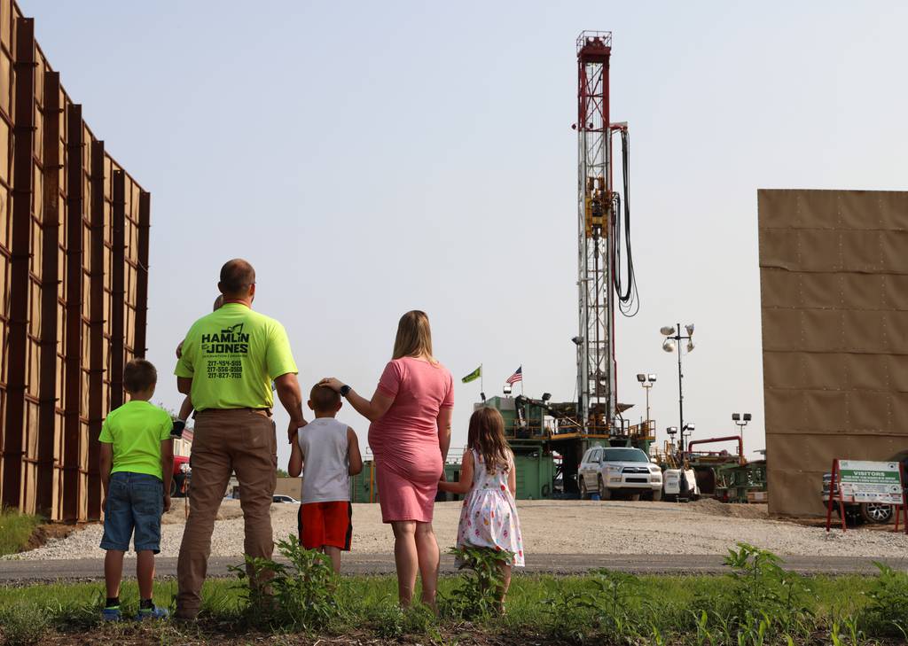 Ralph and Sabrina Jones stand with their children across the road from the Navigator CO2 drilling site located in rural Nokomis.