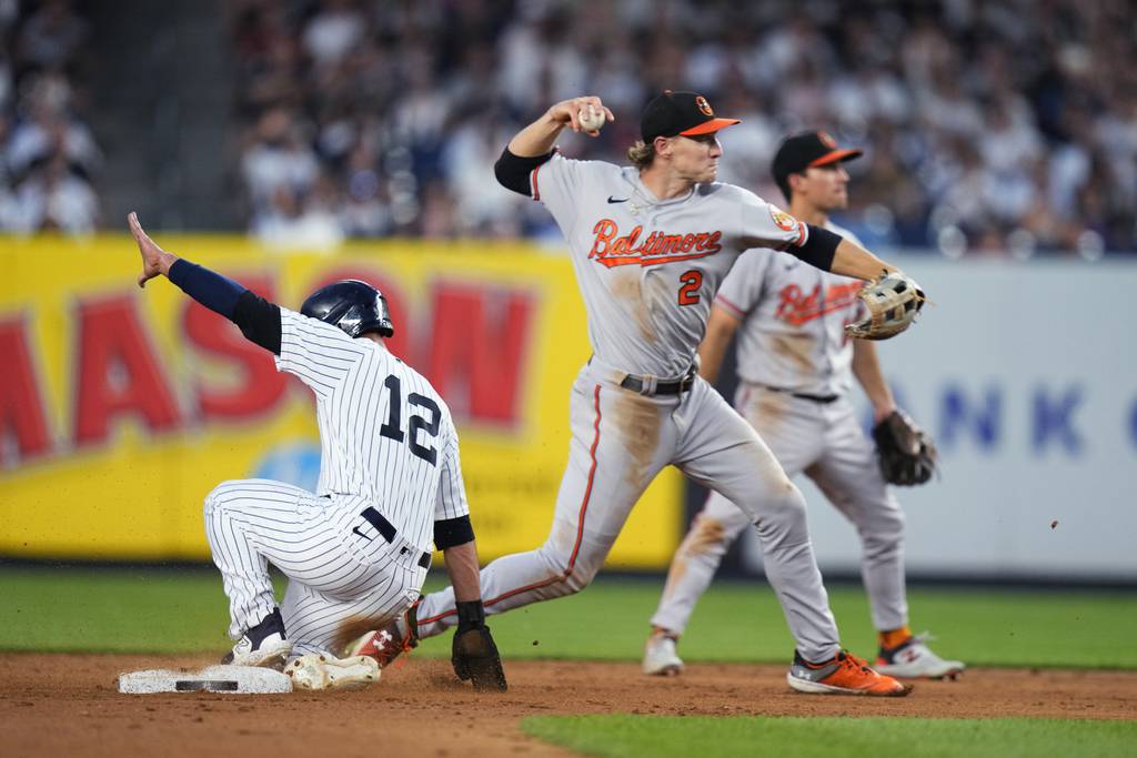 The Orioles' Gunnar Henderson throws wildly to first base after forcing out New York Yankees' Isiah Kiner-Falefa during the fifth inning. The ball struck a YES Network cameraman in the head.