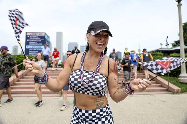 Jessica Holecek waves checkered flags at Buckingham Fountain during the NASCAR Chicago Street Race on July 1, 2023.