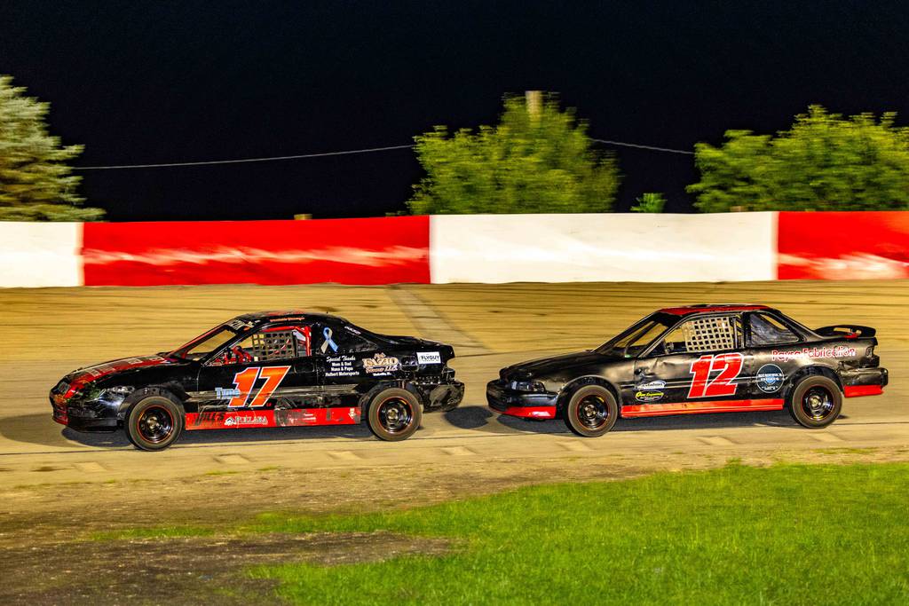 Danielle Dobczyk (17) fends off a challenge from Dan Schmeissing during the pure stocks feature race at Grundy County Speedway on Friday, July 7, 2023.