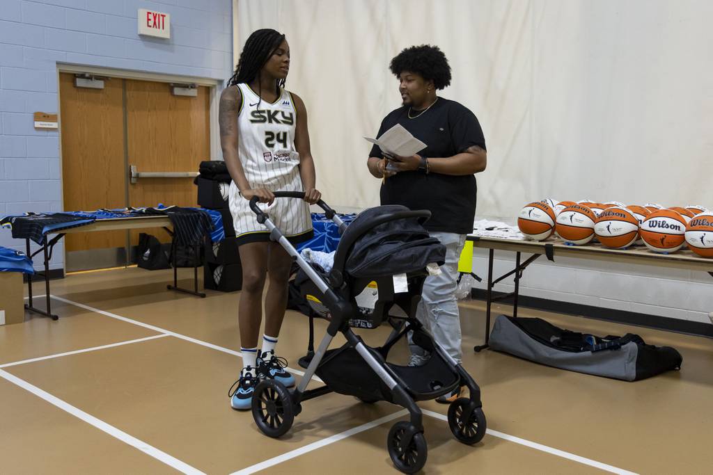 Chicago Sky forward Ruthy Hebard pushes her one-month-old baby, Xzavier, in a stroller between pictures on May 10, 2023, at media day.