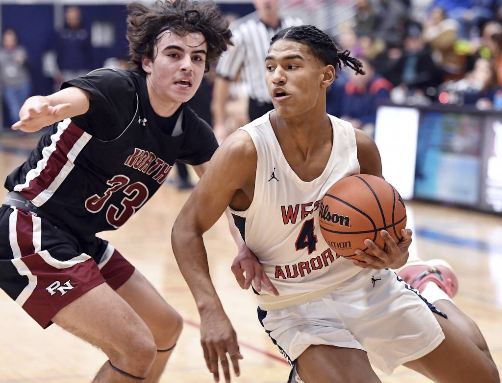 West Aurora’s Josh Pickett (4) drives past Plainfield North's Jeffrey Fleming (33) during a Southwest Prairie West game in Aurora on Friday, Feb. 10, 2023.