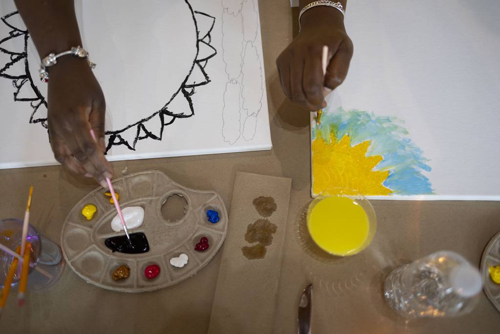 Participants begin their paintings on July 16, 2023, at Vault Gallerie in Pilsen during a Ladies of the Arc event for mothers who have lost children to gun violence. 
