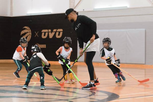 Akim Aliu, co-founder of the Hockey Diversity Alliance and former professional hockey player, works with children during a ball hockey skills program at the Malvern Recreation Centre in Toronto on June 12, 2022.