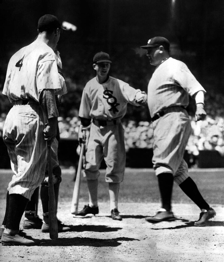 Babe Ruth crosses the plate after hitting the first home run in All-Star game history on July 6, 1933, at Comiskey Park. It was a two-run shot in the third inning and provided the winning margin in the American League's 4-2 victory. Greeting Ruth at home are teammate Lou Gehrig and batboy John McBride.