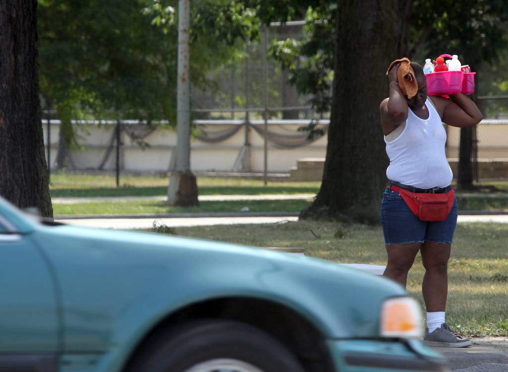 A refreshment street vendor can hardly take the heat herself as she sells her wares at Western Avenue in Chicago during yet another 90-plus degree day on July 5, 2012.  