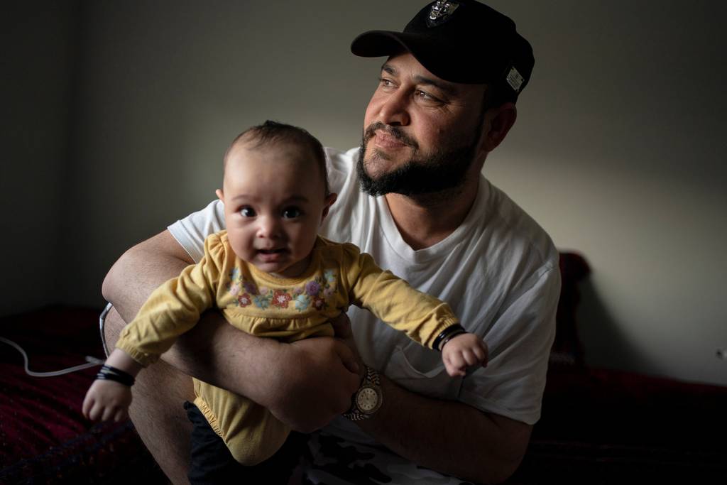 Romal holds his daughter, Athar, in a home they are living in on June 26, 2023, in the suburban Seattle area.