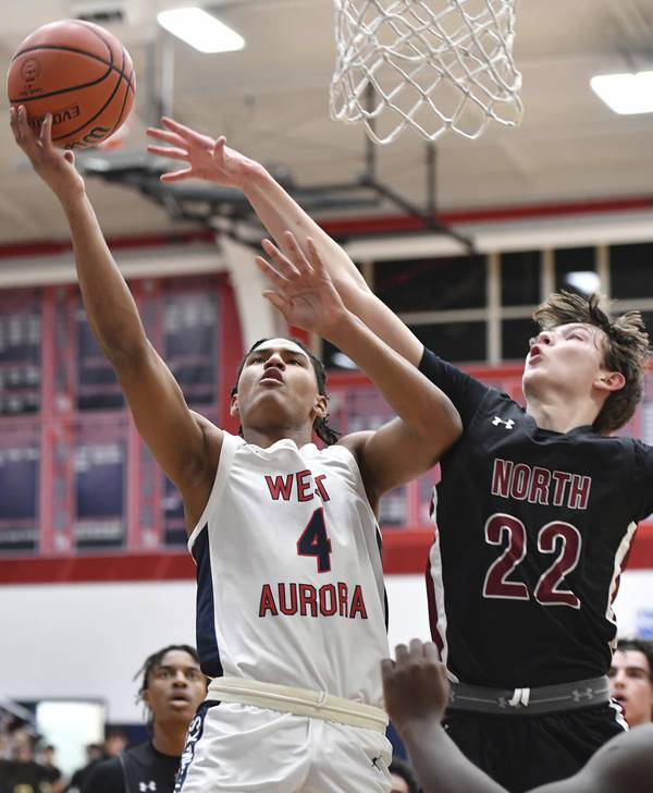 West Aurora's Josh Pickett (4) lays the ball up as Plainfield North's Evan Czarnik (22) defends during a Southwest Prairie West game in Aurora on Friday, Feb. 10, 2023.