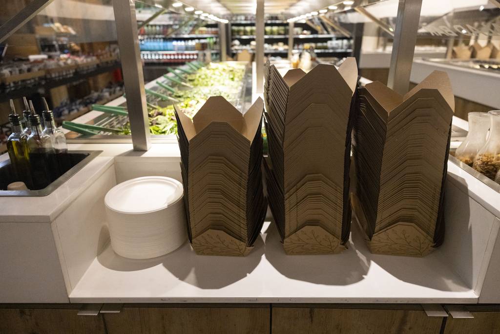 Compostable plates and to-go containers are stacked at Beatrix Market.