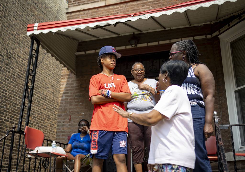Paris Head, 12, talks to neighbors during a block party on his Humboldt Park street, July 16, 2023, ahead of his trip to play in Taiwan.