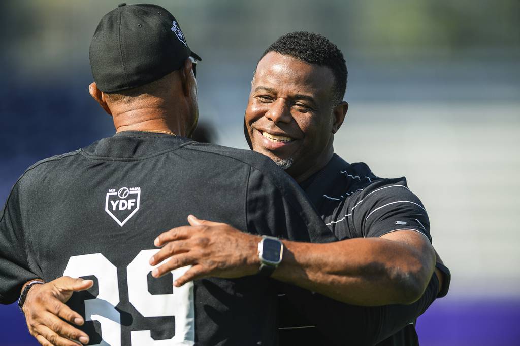 MLB Hall of Fame player Ken Griffey Jr. embraces a member of the coaching staff during a workout session the day before the HBCU Swingman Classic on July 6, 2023.