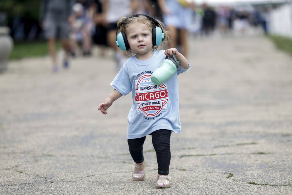 Brooklyn Perez walks through Grant Park with her mother during Day 1 of the NASCAR Chicago Street Race on July 1, 2023.