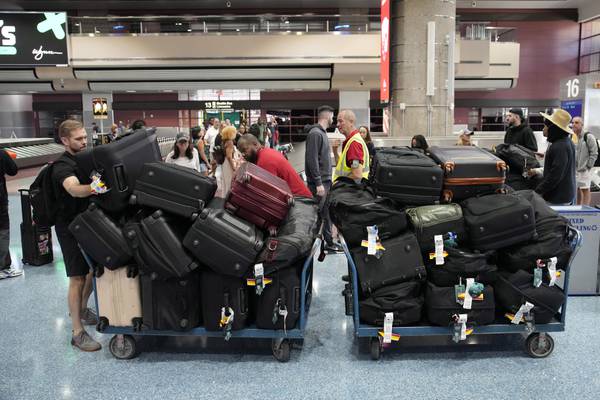 Airport baggage handlers and New York Liberty staff help stack bags at Harry Reid International Airport on June 28, 2023.