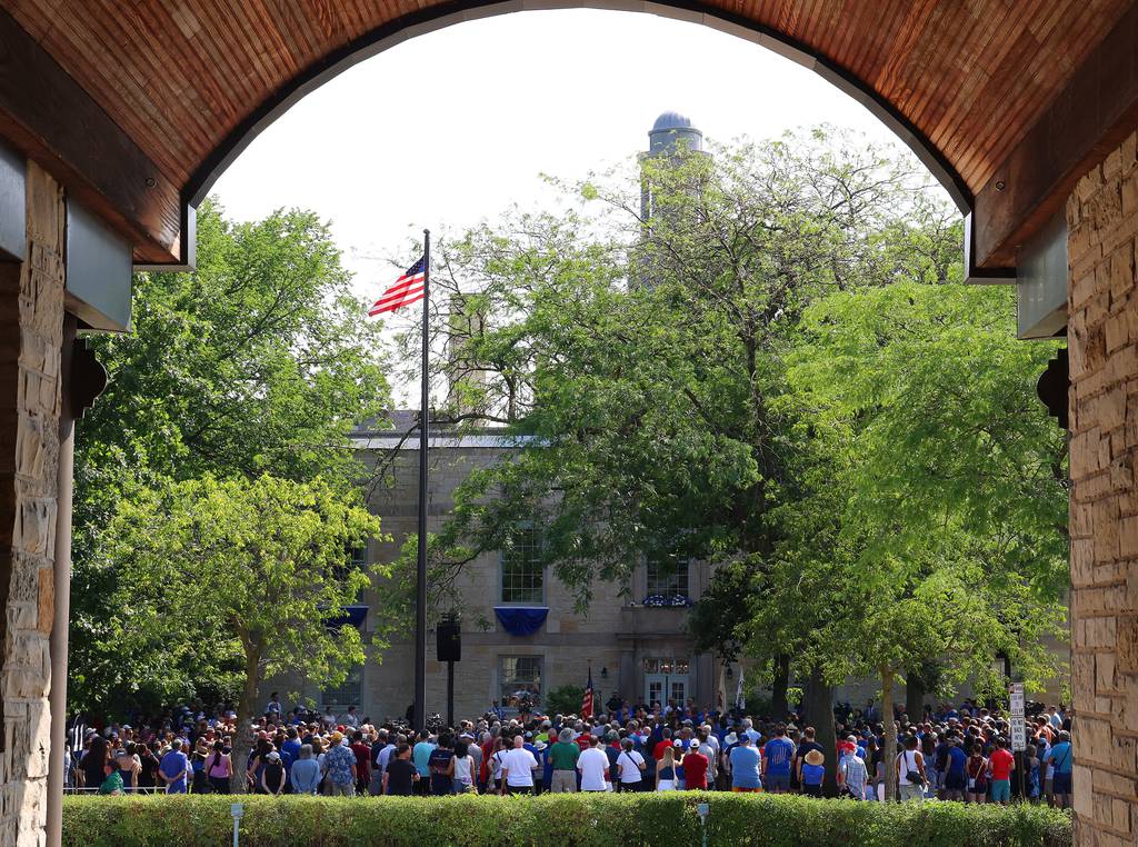 Family and community members gather, July 4, 2023, on the lawn of City Hall for a remembrance ceremony for those killed and injured one year ago.