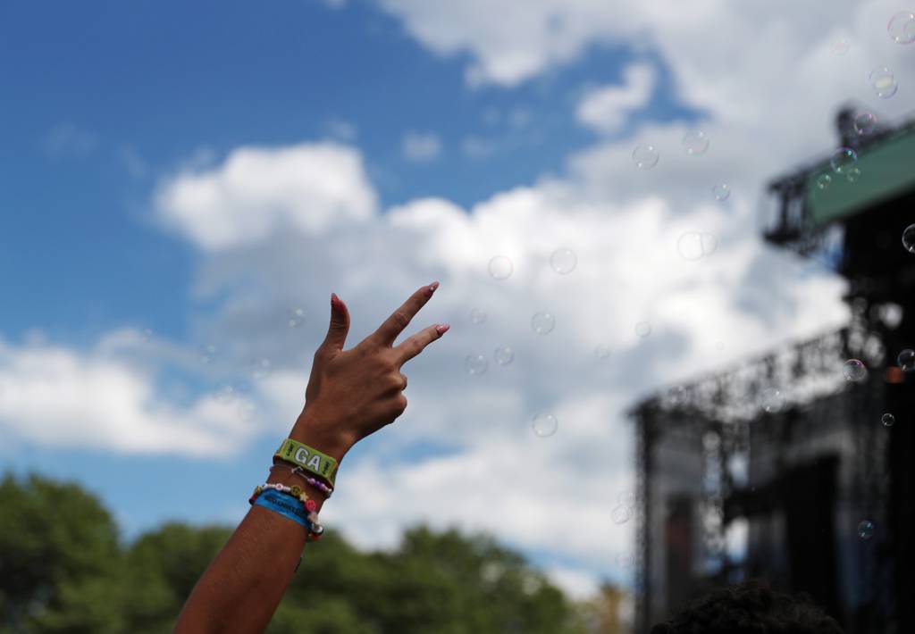 A festival goer raises her hand to electronic dance music at Lollapalooza on July 29, 2022, in Chicago.