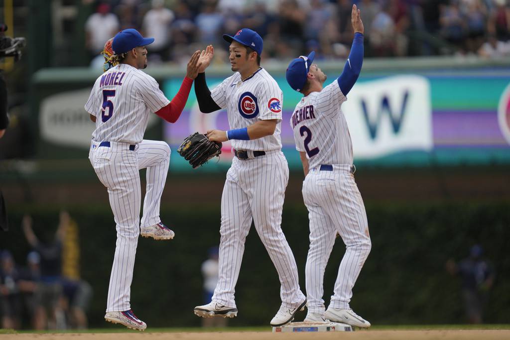Cubs second baseman Christopher Morel, left, right fielder Seiya Suzuki, middle, and shortstop Nico Hoerner celebrate after their 10-4 victory against the Red Sox on Saturday at Wrigley Field.