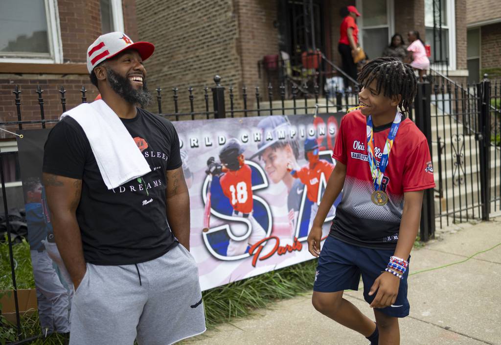 Paris Head laughs with one of his coaches, David Reed, during a block party Sunday, Aug. 13, 2023, in West Humboldt Park.