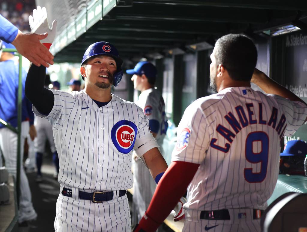 Chicago Cubs right fielder Seiya Suzuki is congratulated by teammate Jeimer Candelario in the dugout after Suzuki hit a solo home run in the fourth inning of a game against the Chicago White Sox at Wrigley Field on Aug. 15, 2023.