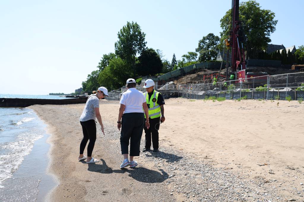 A private security officer speaks with Vicki Apatoff, left, and Mary Garrison, right, along the beach in front of Justin Ishbia lakefront property in Winnetka on Wednesday, July 19, 2023. The security guard believed the women were trespassing and called 911, however Winnetka police have informed residents they are legally allowed on the beach.