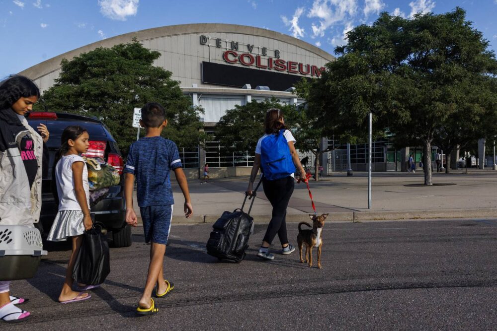 The Mendez family arrives at the Denver Coliseum, driven there by Owen Ceballos, a fellow Venezuelan, on July 14, 2023, in Denver. Ceballos said he came to Denver eight months ago and earns money by shuttling migrants from the bus station to the temporary shelter in the coliseum.