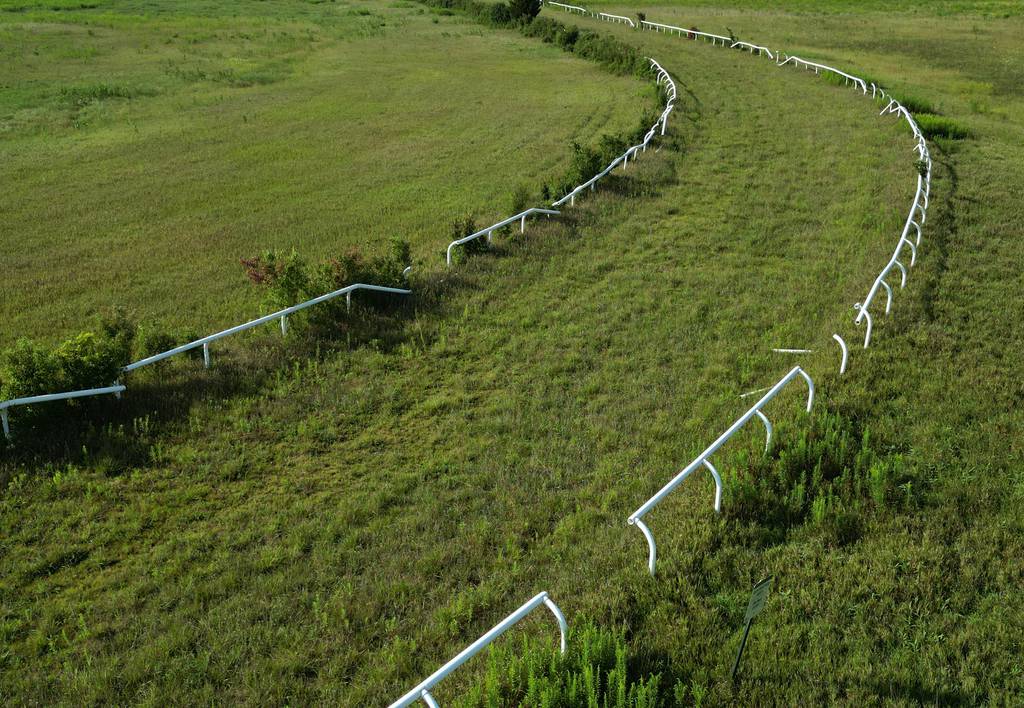 Broken sections of the rail and overgrown grass make up some of the horse track at Horizon Farm preserve on Aug. 18, 2023, in Barrington Hills.