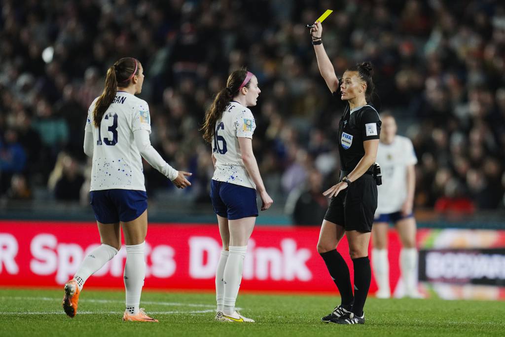 Referee Rebecca Welch shows a yellow card to United States' Rose Lavelle as teammate Alex Morgan reacts during a World Cup match against Portugal on Aug. 1, 2023.