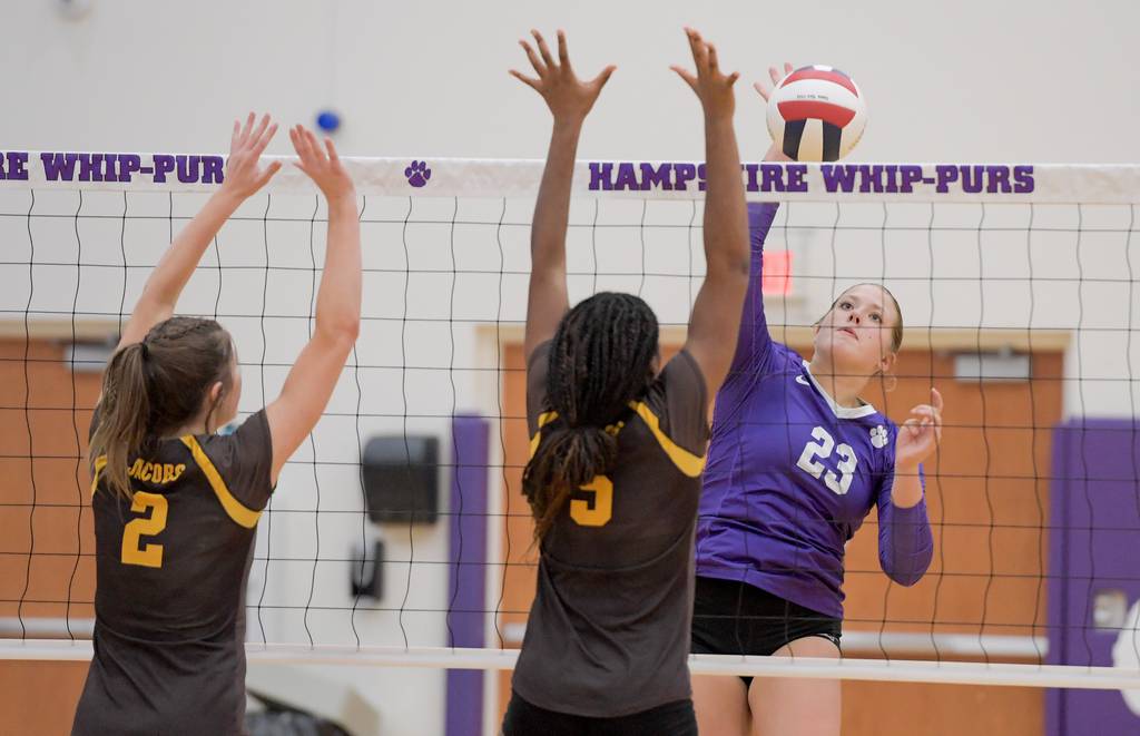 Hampshire's Hailey Homola (23) hits the ball past Jacobs' Cassie Gorrity (2) and Ali Pierre (5) in the second game of a Fox Valley Conference match in Hampshire on Thursday, Aug. 24, 2023.